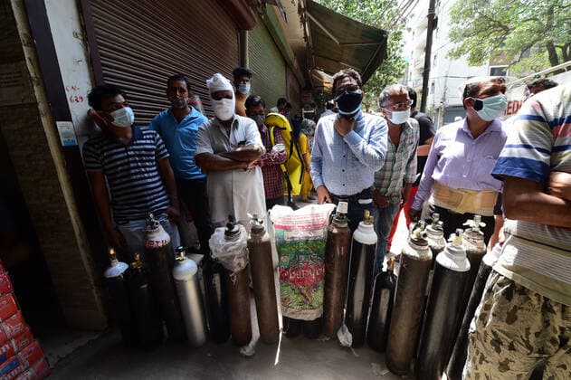 Family members of COVID-19 patients wait outside an oxygen-filling center to refill their empty cylinders, as demand for the gas rises due to spike in coronavirus cases, in New Delhi, India on Monday, May, 3, 2021.  DEL20210503010 Abhishek