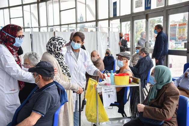 Coronavirus in Tunesien, Impfzentrum in Tunis May 3, 2021, Tunis, Tunisia: A Tunisian healthcare worker assists an elderly woman during inoculation at El-Menzah sports hall in Tunisia s capital. Tunis Tunisia - ZUMAs197 20210503_zaa_s197_059 Copyright: xJdidixwassimx