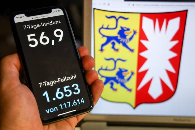 Coronavirus in Germany Covid 19 Dashboard of the Robert Koch Institute DEU, Germany, Schleswig Holstein, 04 05 2021 The 7-day incidence for the state Cases last 7 days 100 000 P.E. is displayed on an iPhone, with the state coat of arms in the background.