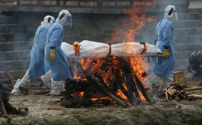 May 4, 2021, Kathmandu, Nepal: Men wearing personal protective equipment (PPE) carry the body of a COVID-19 victim for cremation on the bank of Bagmati River, in Kathmandu, Nepal May 4, 2021. Kathmandu Nepal - ZUMAs242 20210504_zip_s242_003 Copyright: xDipenxShresthax