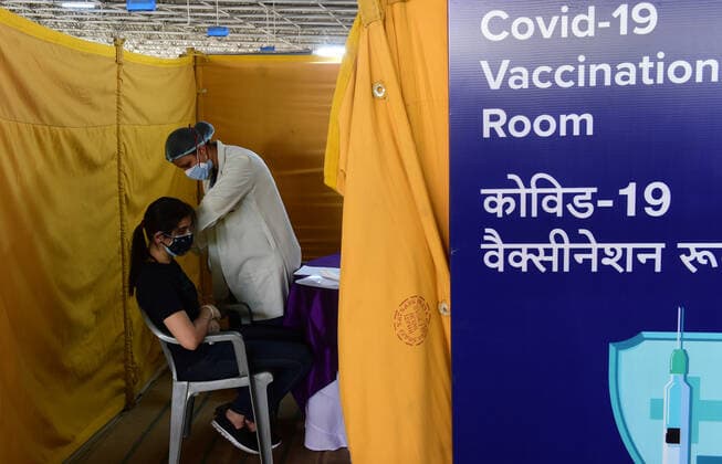 A young person receives the first dose of COVID-19 vaccine, at one of the largest vaccination sites at Radhaswami Satsang, in New Delhi, India, Tuesday, May 4, 2021. More than 20 million Indians have been infected with the coronavirus as it continues to spread with 3,500 deaths in the past 24 hours.  DEL2021050421 Abhishek