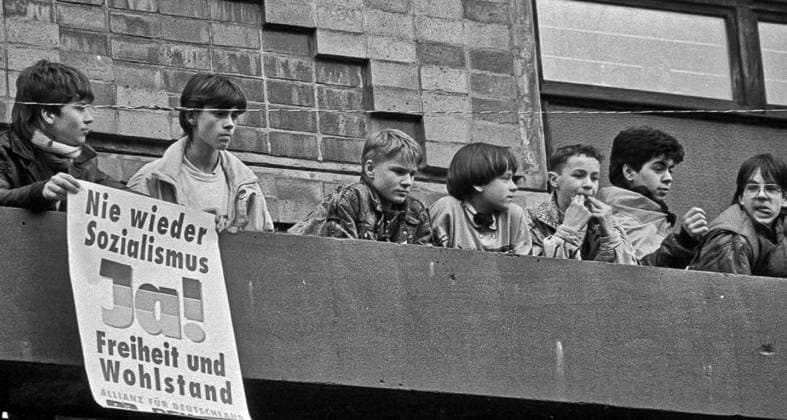 Rabatz gegen PDS-Mann Gregor Gysi im Wahlkampf 1990 in Rostock Szene aus dem Rostocker Wahlkampf zur ersten frei zu wählenden Volkskammer der DDR im März 1990. Diese jungen Burschen machten kräftigen Rabatz gegen die Wahlkampfveranstaltung der PDS mit Gregor Gysi. Ihre klare Ansage steht auf dem Plakat: Nie wieder Sozialismus - Freiheit und Wohlstand. Allianz für Deutschland. Rostock Mecklenburg-Vorpommern Deutschland *** Riot against PDS man Gregor Gysi in the 1990 election campaign in Rostock Scene from the Rostock election campaign for the first freely electable Volkskammer of the GDR in March 1990 These young boys made a big racket against the election campaign event of the PDS with Gregor Gysi Their clear message is written on the