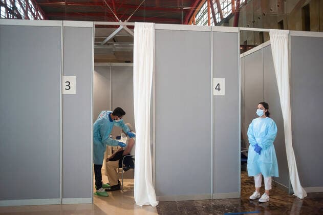 May 5, 2021, Malaga, Spain: A woman is being vaccinated as a health worker waits for people during a massive vaccination at Fair and Congresses Palace..Health regional authorities have retimed again the vaccination with doses of Pfizer BioNTech inside large and secure places following all protective measures, as part of massive vaccination One million plan after the announcement of Andalusian government to inoculate around 600.000 vaccines during the week. Malaga Spain - ZUMAs197 20210505_zaa_s197_009 Copyright: xJesusxMeridax