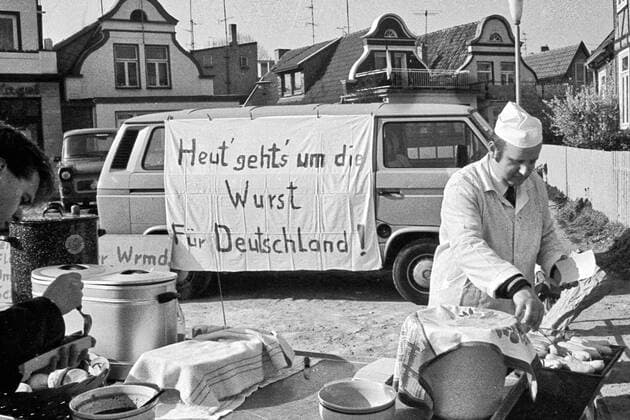 Volkskammerwahl - Heute geht um die Wurst - 18.03.1990 - Rostock: Heute geht es um die Wurst für Deutschland! - Ein Metzger in Warnemünde hält am Tag der Volkskammerwahl Bockwürste kostenlos bereit. Er möchte damit ein Zeichen setzen, wohin das Votum der Wahl ausschlagen soll. Letztendlich erfüllte sich seine Hoffnung für Deutschland. Rostock Mecklenburg-Vorpommern Deutschland *** Peoples Chamber Election Today its all about the sausage 18 03 1990 Rostock Today its all about the sausage for Germany A butcher in Warnemünde holds bockwurst ready for free on the day of the Peoples Chamber Election He wants to send a signal about where the vote should go In the end, his hope for Germany Rostock Mecklenburg-Western Pomerania Germany came
