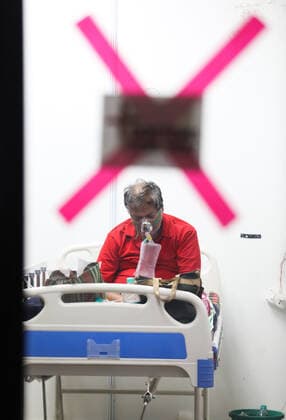 May 5, 2021, New Delhi, India: A Covid-19 infected patient receiving medical oxygen for breathing comfortably seen inside a Covid care center of the Commonwealth Games (CWG) villages temporarily converted into a Covid-19 care facility..In India people experience oxygen shortage in hospitals, and long queues outside the oxygen refilling center during the second wave of the Covid-19 pandemic. New Delhi India - ZUMAs197 20210505_zaa_s197_141 Copyright: xNaveenxSharmax