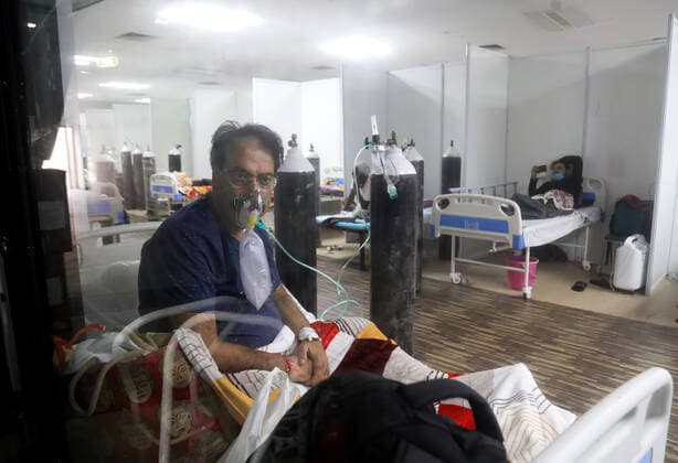 May 5, 2021, New Delhi, India: A Covid-19 infected patient receiving medical oxygen for breathing comfortably seen inside a Covid care center of the Commonwealth Games (CWG) villages temporarily converted into a Covid-19 care facility..In India people experience oxygen shortage in hospitals, and long queues outside the oxygen refilling center during the second wave of the Covid-19 pandemic. New Delhi India - ZUMAs197 20210505_zaa_s197_146 Copyright: xNaveenxSharmax