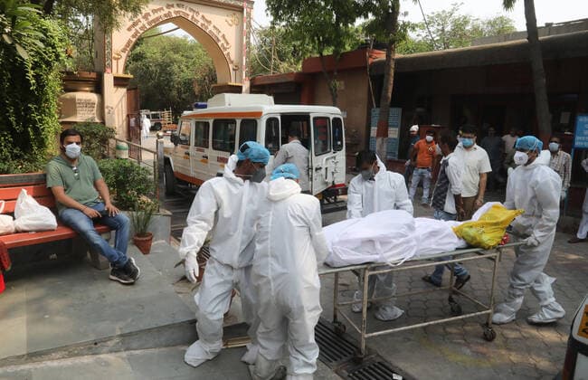 May 5, 2021, New Delhi, India: (EDITORS NOTE: Image depicts death).Family members and health workers carry the body of a person who has lost his life from coronavirus Covid-19 infection for cremation at Nigambodh Ghat crematorium in New Delhi..In India a third wave of the coronavirus is inevitable top scientific adviser said on Wednesday, 05 May, 2021. (A third wave of Covid-19 is inevitable given the amount of virus circulation, K. VijayRaghavan, Principal Scientific adviser to the Government of India has warned. He also added that there is a need to update vaccines to deal with new strains and mutations.) India records 382,146 new covid-19 cases and 3,572 deaths in the last 24 hours. New Delhi India - ZUMAs197 20210505_zaa_s197_163 Copyright: xNaveenxSharmax