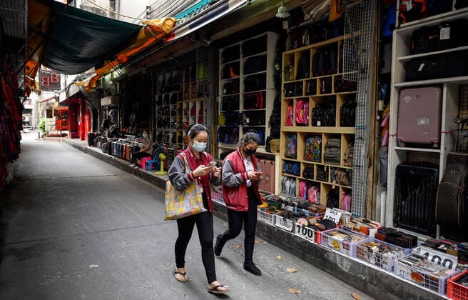 May 5, 2021, Bangkok, Thailand: Women wearing masks walk down a lane past a bag shop at the internationally famous red light district, Patpong,.Bangkok night life entertainment venues, bars, pubs and restaurants are closed in the designated red zone. A partial lockdown has been imposed for 2 weeks during May 3 -17, 2021, due to a recent upsurge of the Covid C-19 virus outbreak in the capital. Bangkok Thailand - ZUMAs197 20210505_zaa_s197_180 Copyright: xPaulxLakatosx