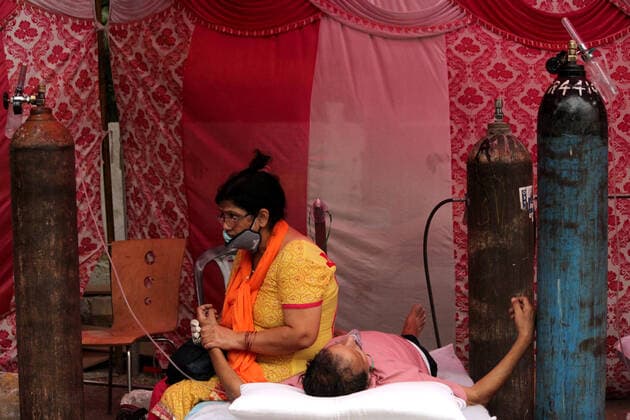 Corona Virus Outbreak In India A man, having difficulty in breathing, is comforted by his wife as he receives free oxygen support outside a Gurudwara (Sikh temple) in Ghaziabad, on the outskirts of New Delhi, India on May 6, 2021. India reported 4,12,262 new cases and 3,980 deaths in the last 24 hours. India had become the first country in the world to register over 4 lakh infections in a single day on April 30, when it reported 4.08 lakh infections. New Delhi India makhija-notitle210506_npw9f  Copyright: xMayankxMakhijax