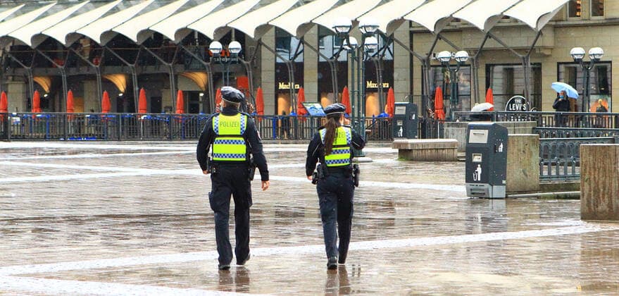Police officers walk across Hamburgs Rathausmarkt square during a rainstorm Altstadt Hamburg