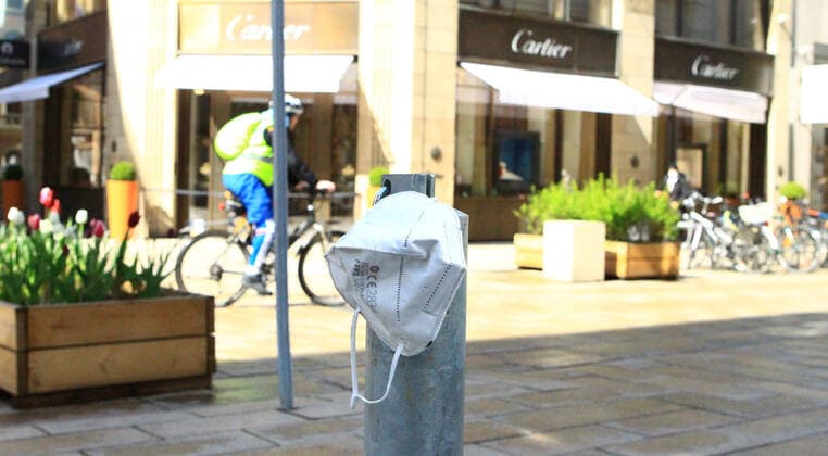 On a bollard in the shopping street Neuer Wall in the city centre of Hamburg hangs a mouth nose mask Altstadt Hamburg