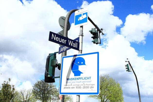 A sign hangs on a pole in front of the Neuer Wall shopping street in Hamburgs city centre, indicating that masks are compulsory in this area at certain times Altstadt Hamburg