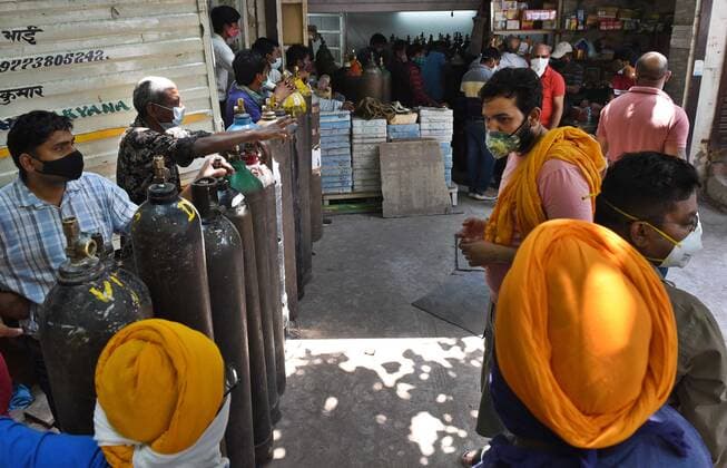 NEW DELHI, INDIA - MAY 7: Peope at an oxygen cylinder refilling centre at Bhogal on May 7, 2021 in New Delhi, India. (Photo by Ajay Aggarwal Hindustan Times) India Faces Oxygen Crisis As Covid-19 Cases Mount
