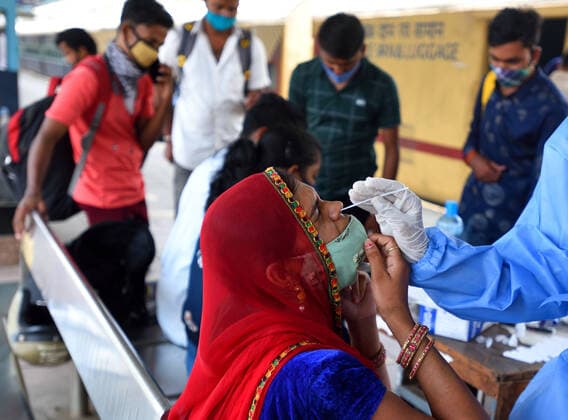 MUMBAI, INDIA - MAY 7: A BMC healthcare worker collects a swab sample of a passenger arriving from outstation trains at Dadar station,, on May 7, 2021 in Mumbai, India. (Photo by Satish Bate Hindustan Times) Medical Team Conducts COVID-19 Coronavirus Test