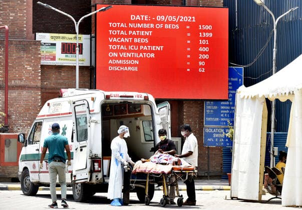 NEW DELHI, INDIA - MAY 9: Medical workers in Personal protective equipment (PPE) with others shifted to a covid corona virus patients on a stretcher outside the Covid-19 ward at Lok Nayak Jai Prakash (LNJP) hospital, on May 9, 2021 in New Delhi, India. (Photo by Sonu Mehta Hindustan Times ) Daily Life Amid Coronavirus Pandemic In India