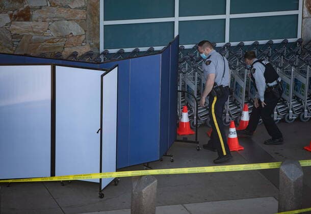 May 9, 2021, Richmond, BC, Canada: RCMP officers search around rows of luggage carts as screens block off an area of the sidewalk after a shooting outside the international departures terminal at Vancouver International Airport, in Richmond, B.C., Sunday, May 9, 2021. Richmond Canada  - ZUMAc35_ 20210509_zaf_c35_064 Copyright: xDarrylxDyckx
