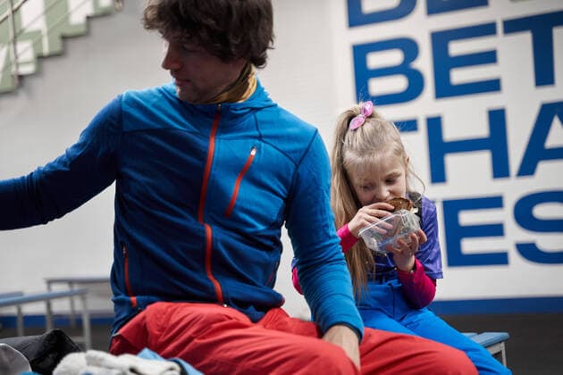 Young father and daughter eating tasty sandwich wearing sports clothes sitting together on bench in sports club, Model released Copyright: xSergeyxMironovx MR
