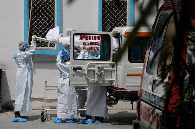 May 11, 2021, New Delhi, India: (Editors note image depicts death).Health workers wearing Personal Protective Equipment suits (PPE) carry the body of a Covid-19 victim outside the mortuary of Lok Nayak Jai Prakash Narayan Hospital (LNJP) one of the largest COVID-19 facilities with more than 1,500 beds and 500 ICU (intensive care Unit) beds. U.S. top medical expert Anthony Fauci has suggested the complete lockdown in India and vaccinate the entire population at earliest to stop the violent spread of Covid-19 in the country. India has recorded 329,942 new covid-19 cases and over3, 800 death in the past 24 hours. New Delhi India - ZUMAs197 20210511_zaa_s197_087 Copyright: xNaveenxSharmax