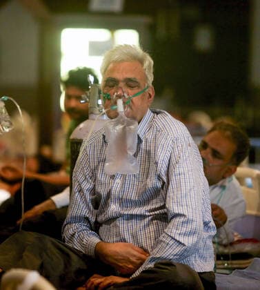 May 11, 2021, New Delhi, India: A Covid-19 patient wearing an oxygen mask inside a Covid-19 care center set up at Shehnai Banquet Hall, attached with Lok Nayak Jai Prakash Narayan Hospital (LNJP) one of the largest COVID-19 facilities with more than 1,500 beds and 500 ICU (intensive care Unit) beds. U.S. top medical expert Anthony Fauci has suggested the complete lockdown in India and vaccinate the entire population at earliest to stop the violent spread of Covid-19 in the country. India has recorded 329,942 new covid-19 cases and over3, 800 death in the past 24 hours. New Delhi India - ZUMAs197 20210511_zaa_s197_093 Copyright: xNaveenxSharmax