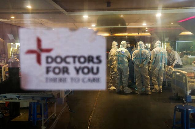 May 11, 2021, New Delhi, India: Doctors and healthcare staff wearing Personal Protective Equipment suits (PPE) attend to Covid-19 patient inside a Covid-19 care center set up at Shehnai Banquet Hall, attached with Lok Nayak Jai Prakash Narayan Hospital (LNJP) one of the largest COVID-19 facilities with more than 1,500 beds and 500 ICU (intensive care Unit) beds. U.S. top medical expert Anthony Fauci has suggested the complete lockdown in India and vaccinate the entire population at earliest to stop the violent spread of Covid-19 in the country. India has recorded 329,942 new covid-19 cases and over3, 800 death in the past 24 hours. New Delhi India - ZUMAs197 20210511_zaa_s197_095 Copyright: xNaveenxSharmax