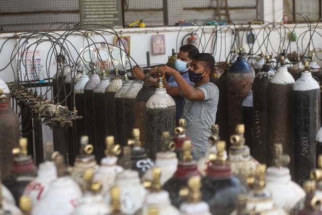 NEW DELHI, INDIA - MAY 11: Empty oxygen cylinders being refilled at a centre at Mayapuri Industrial Area on May 11, 2021 in New Delhi, India. Oxygen has become a crucial medical resource because significantly more patients are suffering from breathlessness in this wave of infections. However with increasing supply of oxygen and decreasing active cases the rush at oxygen refilling center has decreased. (Photo by Amal KS Hindustan Times) Oxygen Supply For Covid Patients