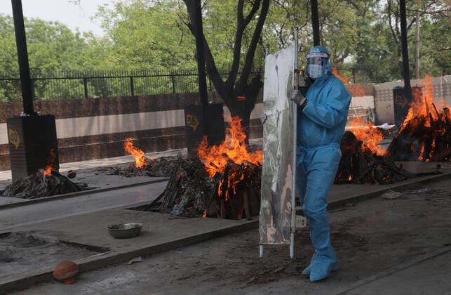 News Bilder des Tages May 14, 2021, New Delhi, India: A health worker dressed in Personal Protection suit (PPE) carries a stretcher after transporting the body of a person who died due to the Covid-19 disease at Mangolpuri crematorium ground in New Delhi..India has recorded 343,144 people testing Covid-19 positive cases and 4,033 fatalities due to coronavirus infection in the last 24 hours according to the data released by Union Health Ministry on Friday. Across the country the cumulative death toll now stands at 262,317 while 20,079,599 people have recovered from the virus in the country. New Delhi India - ZUMAs197 20210514_zaa_s197_081 Copyright: xNaveenxSharmax