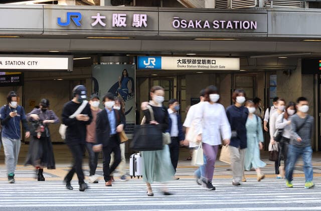 May 15, 2021, Osaka, Japan - People cross a road outside of the Osaka station amid outbreak of the new coronavirus in Osaka on Saturday, May 15, 2021. Japanese government announced to expand a COVID-19 state of emergency on May 14.  (160323369)