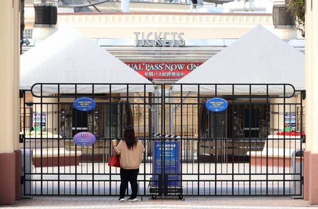May 15, 2021, Osaka, Japan - A woman checks a notice of the temporary close at the entrance of the Universal Studios Japan amid outbreak of the new coronavirus in Osaka on Saturday, May 15, 2021. Japanese government announced to expand a COVID-19 state of emergency on May 14.  (160323371)