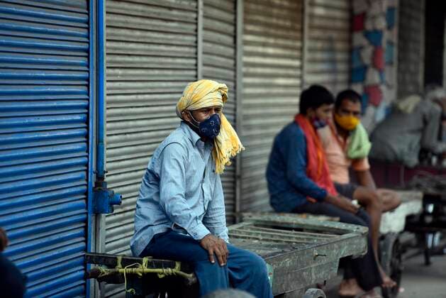 NEW DELHI, INDIA MAY 16: Workers seen outside shuttered shops at Khari Baoli during the Covid-19 induced lockdown, on May 16, 2021 in New Delhi, India. (Photo by Sanjeev Verma Hindustan Times ) Daily Life Amid Coronavirus Pandemic In India
