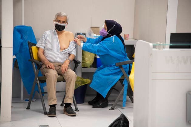 Iran: Vaccination of People over 75 years An Iranian elderly man wearing a protective face mask receives a dose of the China s Sinopharm new coronavirus disease (COVID-19) vaccine in the Iranmall shopping complex in northwest of Tehran. Tehran Iran Iranmall Copyright: SobhanxFarajvan