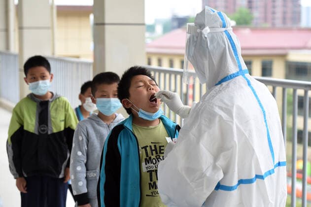 (210517) -- LU AN, May 17, 2021 -- A medical worker collects a swab sample of a student for nucleic acid testing at a primary school in Lu an, east China s Anhui Province, May 17, 2021. Lu an started to conduct a second round of nucleic acid testing for people in the city s main districts and in key areas from Monday to Wednesday, according to the commission. Authorities conducted the first round of testing from May 14 to 16 in the city proper, with more than 1 million samples collected. ) CHINA-ANHUI-LU AN-COVID-19-TEST (CN) ZhouxMu 