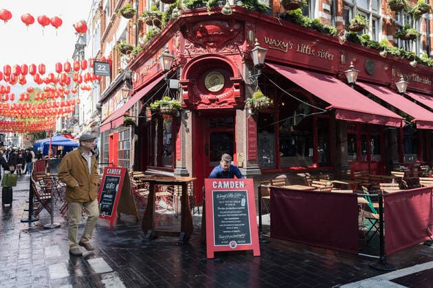 Easing Of Coronavirus Restrictions In London LONDON, UNITED KINGDOM - MAY 17, 2021: A staff member puts signs outside a pub in Chinatown as England moves to Step 3 in easing of coronavirus restrictions, on 17 May, 2021 in London, England. From today indoor hospitality and entertainment venues are allowed to re-open, six people or two households can meet indoors and international travel without need for quarantine resumes to 12 green list countries, however there are concerns that the surge in cases of the Indian Covid variant may delay the fourth stage of easing lockdown on June 21. London Greater London United Kingdom szymanowicz-easingof210517_np0M2  Copyright: xWIktorxSzymanowiczx