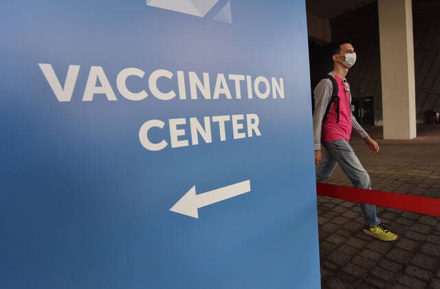 May 17, 2021, Lviv, Ukraine: A man walks past a vaccination center sign outside the vaccination center..The city of Lviv in western Ukraine is offering the IT industry workers to be vaccinated with the AstraZeneca Covid-19 vaccine at a vaccination center located at the Arena Lviv stadium. Lviv Ukraine - ZUMAs197 20210517_zaa_s197_325 Copyright: xPavloxPalamarchukx