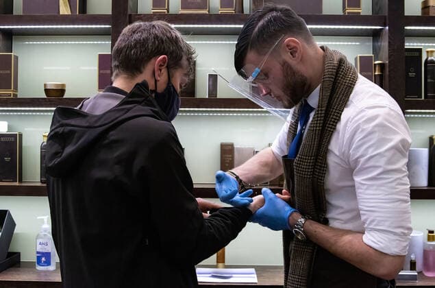 May 17, 2021, London, United Kingdom: A salesman wearing hand glove and face shield putting hand cream onto their customer inside SakarÃ Cosmetics shop. The Prime Minister announced that England can proceed to Stage Three on May 17, 2021. Most shops can reopen including indoor. London United Kingdom - ZUMAs197 20210517_zaa_s197_392 Copyright: xMayxJamesx