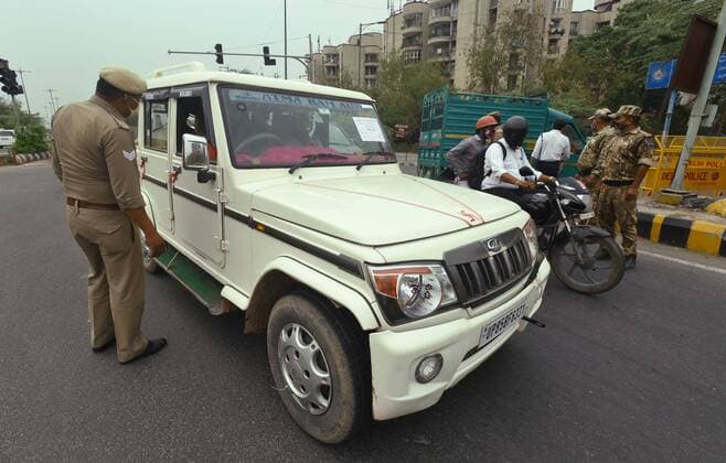 NOIDA, INDIA - MAY 17: Police personnel screen commuters at Noida- Delhi entry gate in Sector 14A, during curfew imposed to curb the spread of COVID-19, on May 17, 2021 in Noida, India. (Photo by Sunil Ghosh Hindustan Times) Daily Life Amid Second Wave Of COVID-19 Pandemic In India