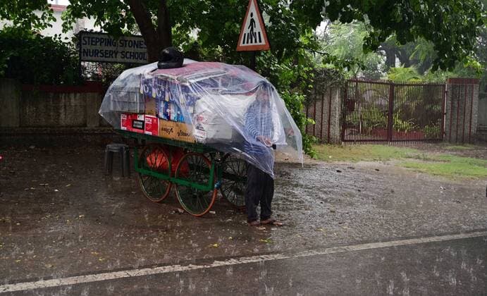 May 19, 2021, Prayagraj, Uttar Pradesh, India: Prayagraj: A road side vendor muffle plastic sheet to being safe from rain shower in Prayagraj on Wednesday, May 19, 2021. Prayagraj India - ZUMAv115 20210519_zap_v115_008 Copyright: xPrabhatxKumarxVermax