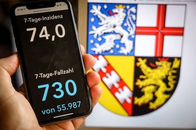 Coronavirus in Germany Covid 19 Dashboard of the Robert Koch Institute DEU, Germany, Saarland, 21 05 2021 The 7-day incidence for the state Cases last 7 days 100 000 PE is displayed on an iPhone, with the state coat of arms in the background.