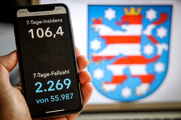 Coronavirus in Germany Covid 19 Dashboard of the Robert Koch Institute DEU, Germany, Thuringia, 21 05 2021 The 7-day incidence for the state Cases last 7 days 100 000 p.e. is displayed on an iPhone, in the background the state coat of arms