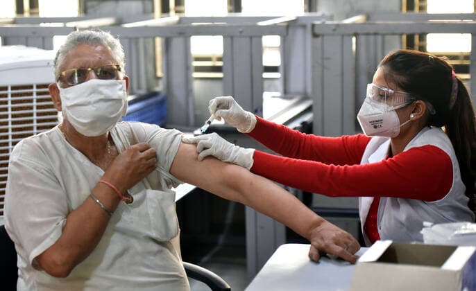 NEW DELHI, INDIA - MAY 21: A health worker administers a shot of Covishield Covid vaccine to a Senior citizen beneficiary during walk for vaccination drive 45+ vaccination Drive at Government Sarvodaya Vidyalaya Krishna Nagar on May 21, 2021 in New Delhi, India. (Photo by Sonu Mehta Hindustan Times) COVID-19 Vaccination Drive