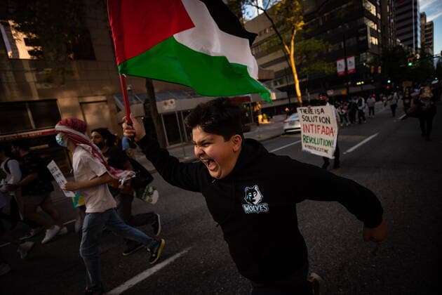 May 22, 2021, Vancouver, BC, Canada: Marwan Qaddo, 11, runs with a Palestinian flag during a march after a vigil in support of the Palestinian people in their conflict with Israel, in Vancouver, on Saturday, May 22, 2021. Vancouver Canada - ZUMAc35_ 20210522_zaf_c35_122 Copyright: xDarrylxDyckx
