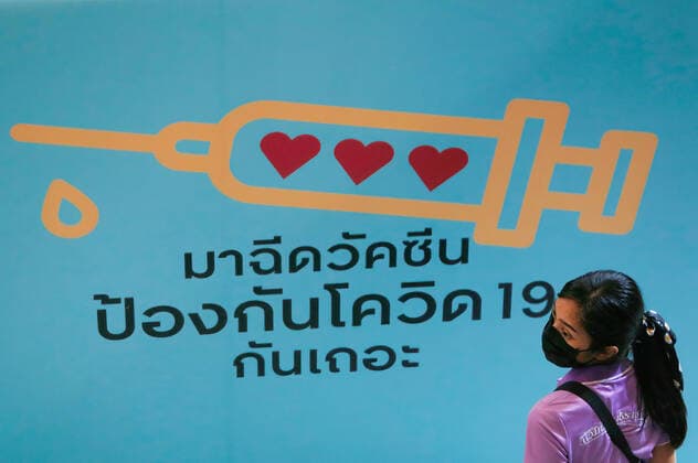 May 23, 2021, Bangkok, Thailand: A woman wearing a face mask as a precaution against the spread of covid-19 walks past a poster at the vaccination center..Thailand has detected the South African variant of the coronavirus among a cluster of infected undocumented migrants in Narathiwat province. Independent scientists and members of the Covid-19 Network Investigations group on Saturday reported to the Public Health Ministry that they found the B.1.351 variant, commonly known as the South African strain, from samples the ministry collected from the cluster in Tak Bai district on May 13. Bangkok Thailand - ZUMAs197 20210523_zaa_s197_022 Copyright: xChaiwatxSubprasomx
