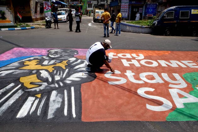 (210523) -- KOLKATA, May 23, 2021 -- A man draws graffiti on the road in front of a building converted into a care center with oxygen support for COVID-19 patients in Kolkata, India, on May 23, 2021. (Str Xinhua) INDIA-KOLKATA-COVID-19-CARE CENTER Stringer 