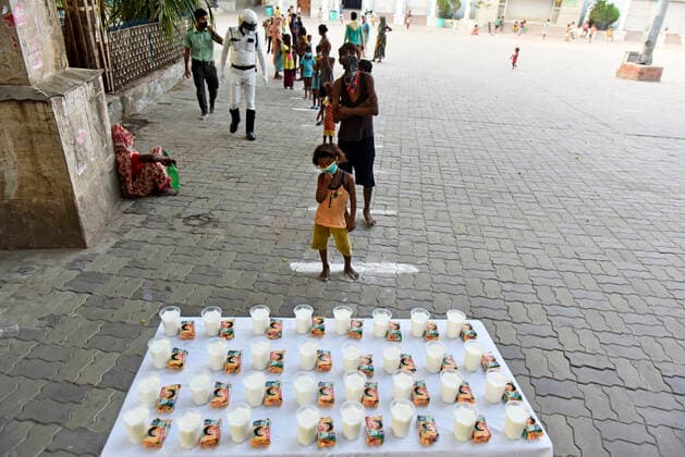 Coronavirus Emergency In Kolkata Poor children stands in a line during a free glass of milk and biscuit packet distribution organised by Kolkata police amid coronavirus emergency in Kolkata, India, 23 May, 2021. India has surpassed Nigeria when it comes to having the largest population of people living in extreme poverty. India added another 85 million poor to its existing huge numbers that have somehow been surviving below the poverty line. The devastating second wave of Covid-19 may leave a still bigger dent in poverty estimates according to an Indian media report. Kolkata West Bengal India aditya-notitle210523_npVXr  Copyright: xIndranilxAdityax