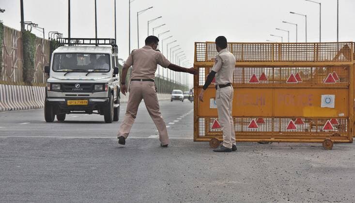 NEW DELHI, INDIA - MAY 23: Delhi Police personnel at a picket while screening commuters for Covid-19 lockdown violations, on NH24 on May 23, 2021 in New Delhi, India. The lockdown in Delhi has been extended by another week and if the daily Covid numbers continue to drop, the process of unlocking will be initiated, Delhi Chief Minister Arvind Kejriwal said today. For now, the lockdown will be in place till 5 am on May 31. Delhi reported 1649 new cases of COVID on May 23. (Photo by Raj K Raj Hindustan Times) Lockdown In Delhi To Contain Spread Of Covid Pandemic