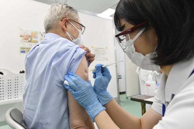 Mass vaccination center in Tokyo A senior citizen (L) receives a coronavirus vaccine shot at a newly opened mass vaccination center in Tokyo on May 24, 2021. (Pool photo) 