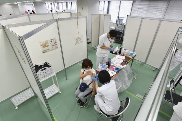 Mass vaccination center in Tokyo A senior citizen receives a coronavirus vaccine shot at a newly opened mass vaccination center in Tokyo on May 24, 2021. (Pool photo) 