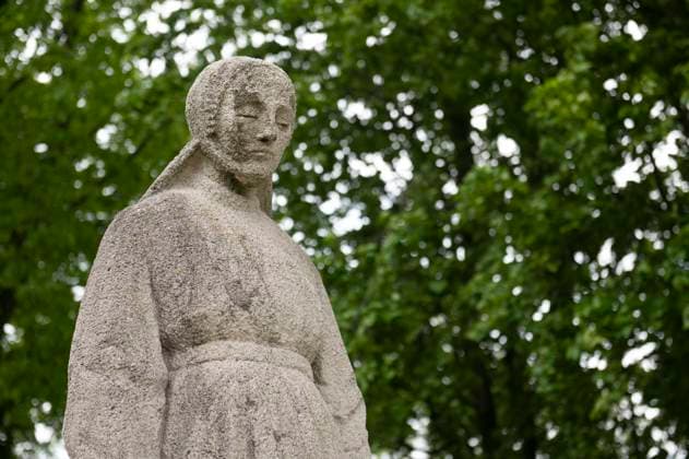 Putten Nederland. Herdenkingshof met Vrouwtje van Putten en 660 symbolische graven. In de Tweede Wereld Oorlog als vergeldingsactie voor een aanslag van de Nederlands verzet hebben de bezettende machthebbers in een razzia 660 Puttense mannen afgevoerd. De overgrote meerderheid daarvan zijn nooit meer teruggekeerd. Putten Netherlands. Memorial court with Vrouwtje van Putten and 660 symbolic graves. In the Second World War, in retaliation for an attack by the Dutch resistance, the occupiers took 660 Putten men, almost the entire male population of the village, away in a raid. The vast majority of these have never returned. Putten Niederlande. Gedenkhof mit Vrouwtje van Putten und 660 symbolischen Gräbern. Im Zweiten Weltkrieg nahmen die B
