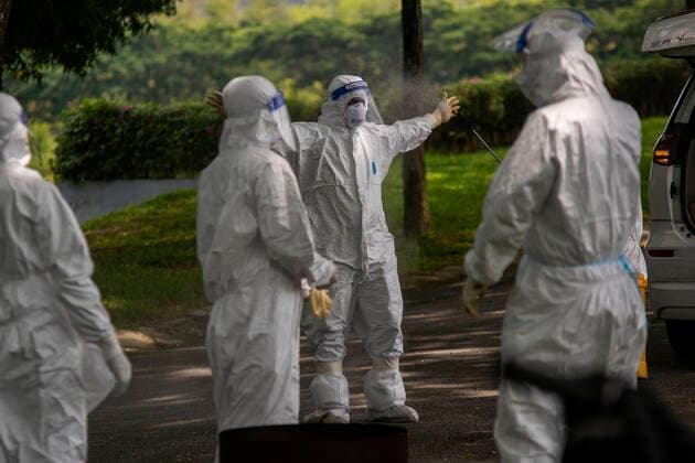 (210526) -- SEMENYIH, May 26, 2021 -- People in protective suits disinfect themselves after burying a COVID-19 victim at a graveyard in Semenyih, Selangor, Malaysia, May 26, 2021. Malaysia on Wednesday reported the highest daily spike of new confirmed COVID-19 cases and deaths since the start of the pandemic, the Health Ministry said. As many as 7,478 new COVID-19 infections were reported, bringing the national total to 533,367. Another 63 deaths have been reported, the highest in a single day, pushing the total deaths to 2,432. (Photo by Xinhua) MALAYSIA-COVID-19-CASES ChongxVoonxChung 