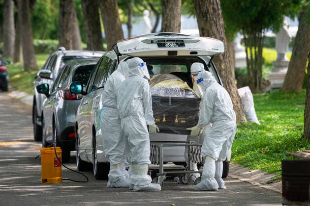 (210526) -- SEMENYIH, May 26, 2021 -- People in protective suits carry a coffin which holds a COVID-19 victim at a graveyard in Semenyih, Selangor, Malaysia, May 26, 2021. Malaysia on Wednesday reported the highest daily spike of new confirmed COVID-19 cases and deaths since the start of the pandemic, the Health Ministry said. As many as 7,478 new COVID-19 infections were reported, bringing the national total to 533,367. Another 63 deaths have been reported, the highest in a single day, pushing the total deaths to 2,432. (Photo by Xinhua) MALAYSIA-COVID-19-CASES ChongxVoonxChung 