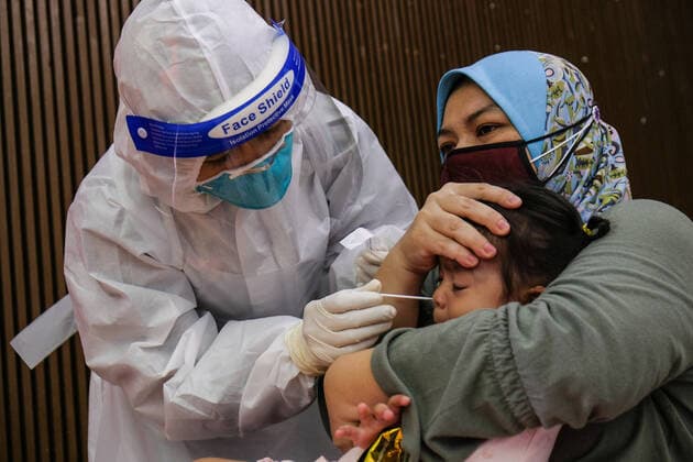 May 26, 2021, Sungai Buloh, Malaysia: A mother holds her child down so as to get the nasal swab sample during the COVID19 testing at a test center in Sungai Buloh..Malaysia has recorded the highest daily cases of Covid-19, yesterday with a record of 7,289 cases. Selangor government continues to conduct mass COVID19 screening tests over the state to battle the coronavirus pandemic. Sungai Buloh Malaysia - ZUMAs197 20210526_zaa_s197_015 Copyright: xFarisxHadziqx